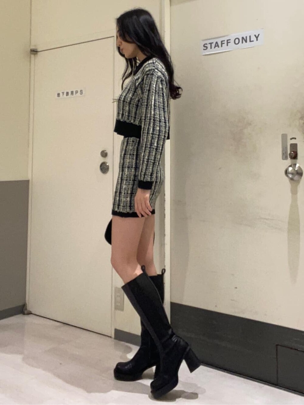 ブラック系のブーツ、ブラック系のスカート、ブラック系のカーディガン/ボレロを着用したレディースの秋コーディネートの3枚目の写真