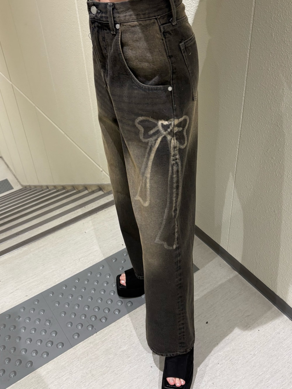 ブラック系のデニムパンツ、ブルー系のTシャツ/カットソー、ブラック系のサンダルを着用したレディースの夏コーディネートの7枚目の写真