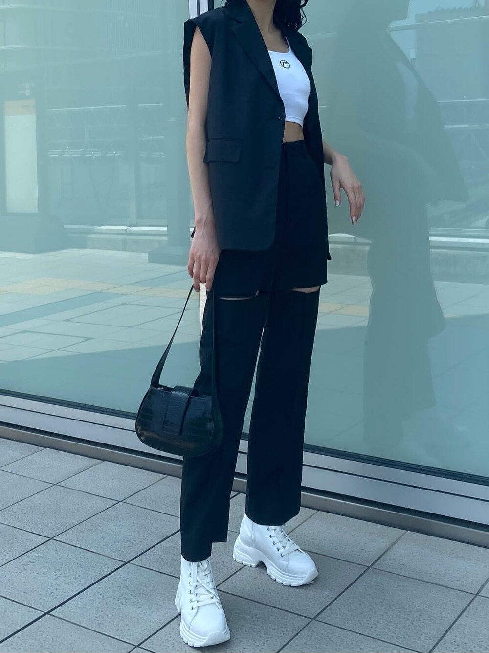 ホワイト系のスニーカー、ブラック系のベスト、ブラック系のその他パンツを着用したレディースの夏コーディネートの5枚目の写真
