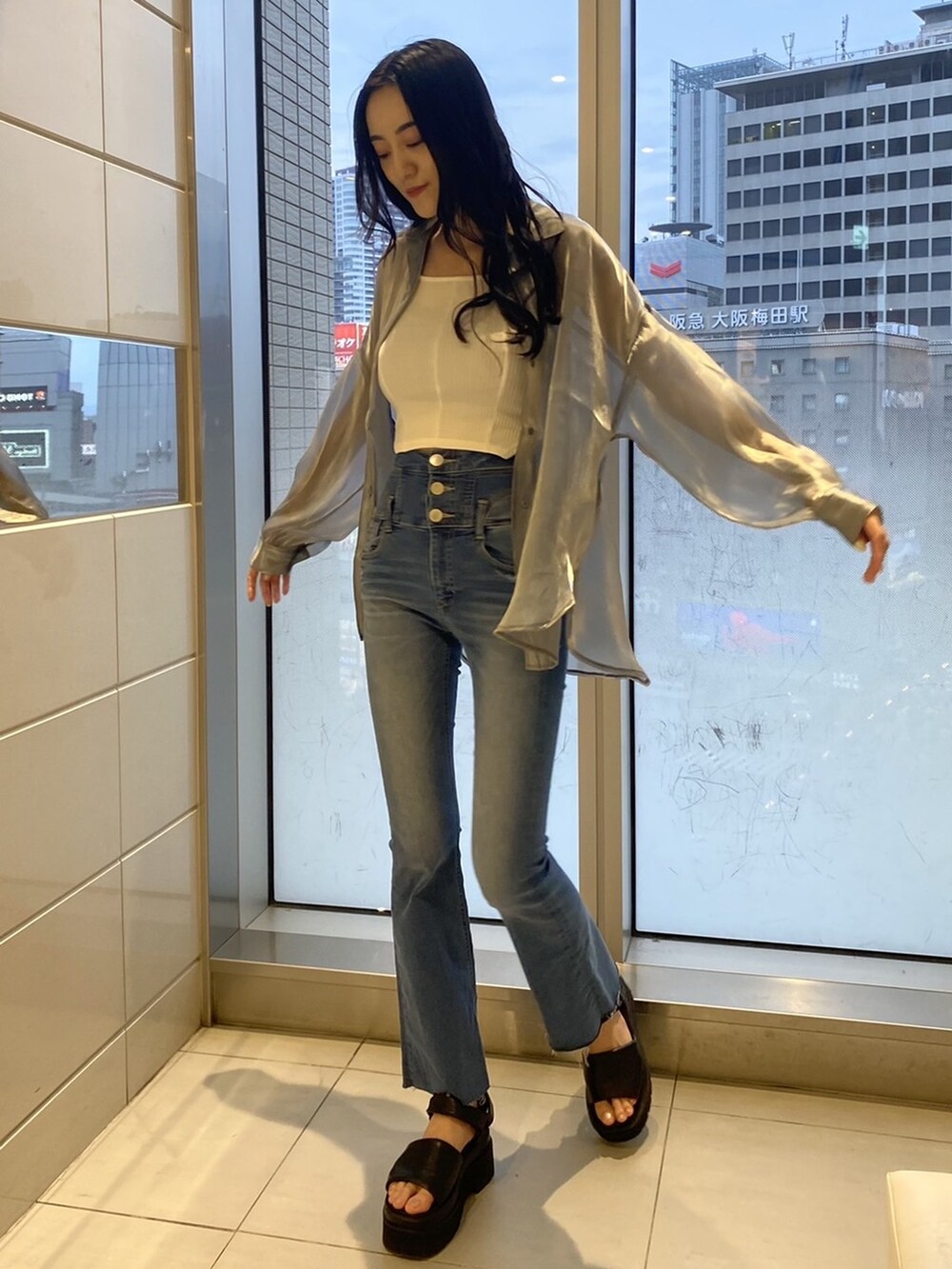 ブラック系のサンダル、グレー系のシャツ/ブラウス、ブルー系のデニムパンツを着用したレディースの夏コーディネートの2枚目の写真