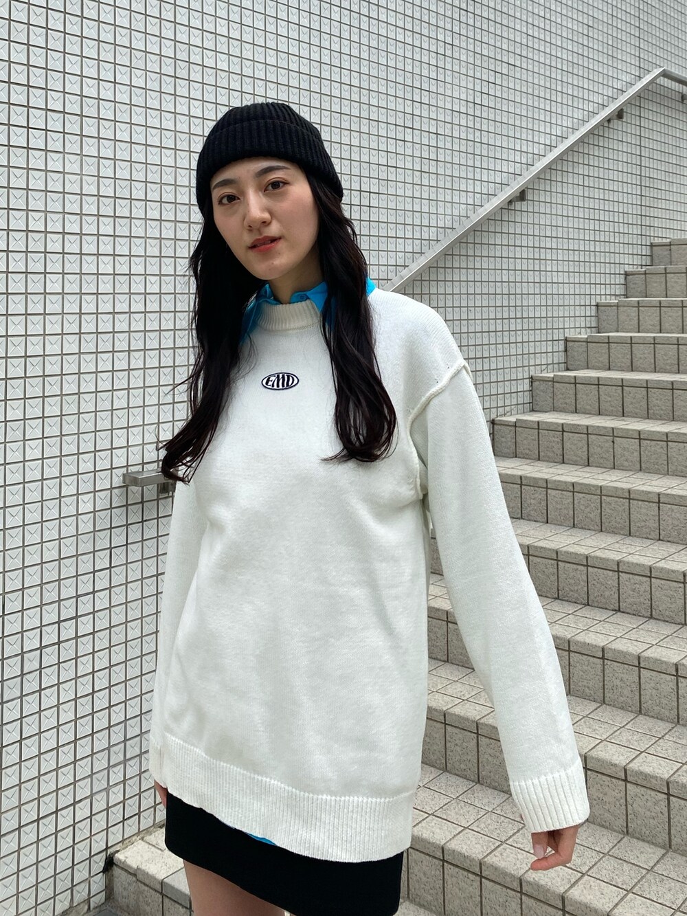 ブルー系のシャツ/ブラウス、ホワイト系のニット/セーター、ブラック系のスカートを着用したレディースの冬コーディネートの5枚目の写真