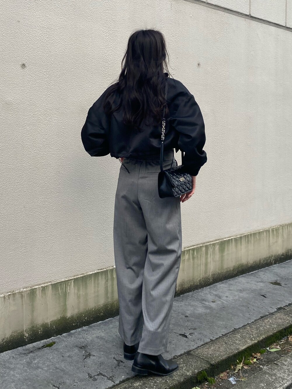 ブラック系のブルゾン、ブラック系のニット/セーター、グレー系のその他パンツを着用したレディースの冬コーディネートの5枚目の写真