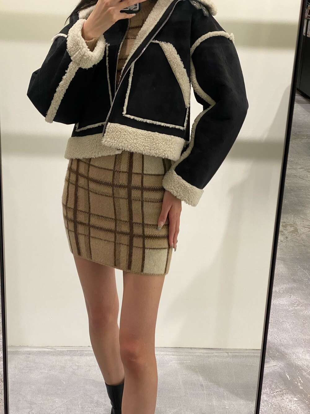 ベージュ系のスカート、ベージュ系のニット/セーター、ブラック系のブーツを着用したレディースの冬コーディネートの4枚目の写真