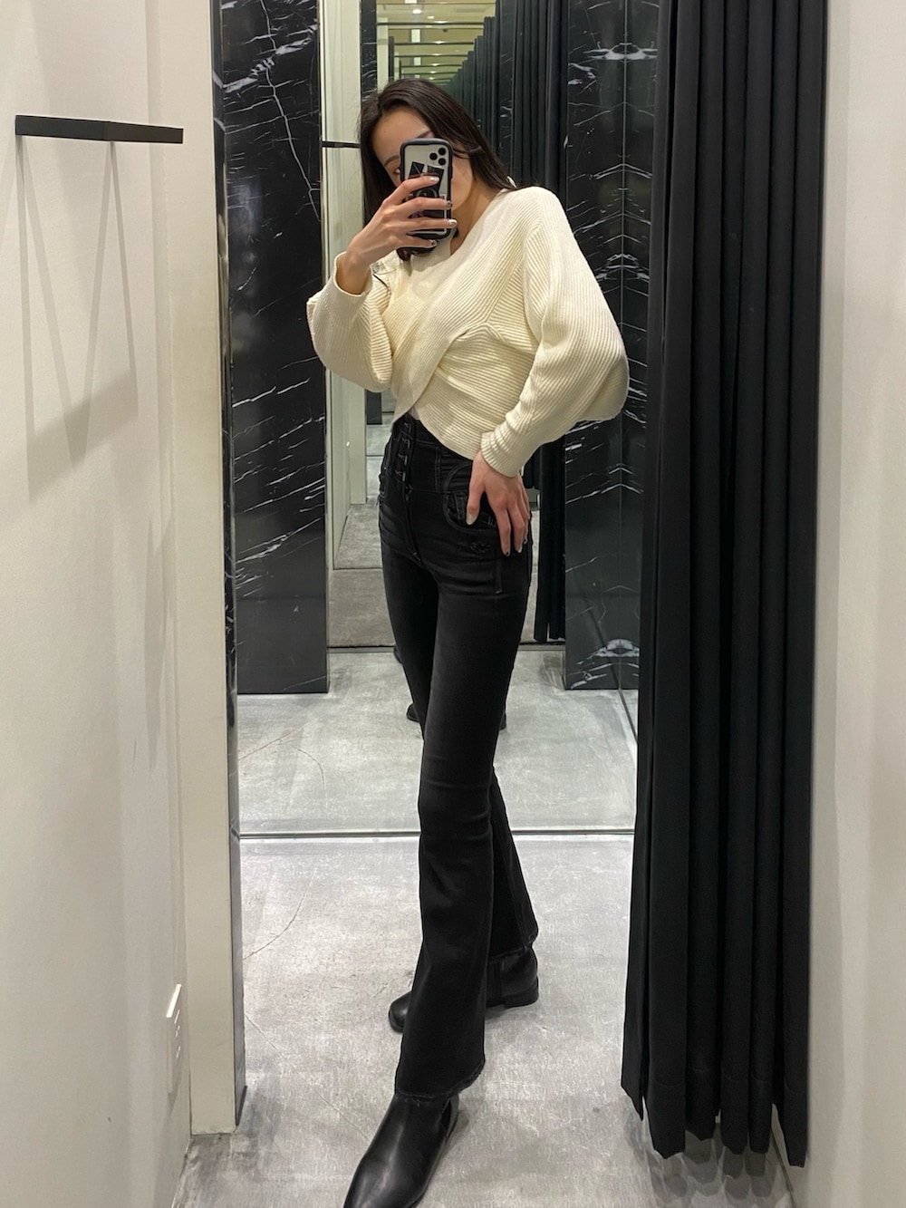 ホワイト系のニット/セーター、ブラック系のデニムパンツを着用したレディースの冬コーディネートの2枚目の写真