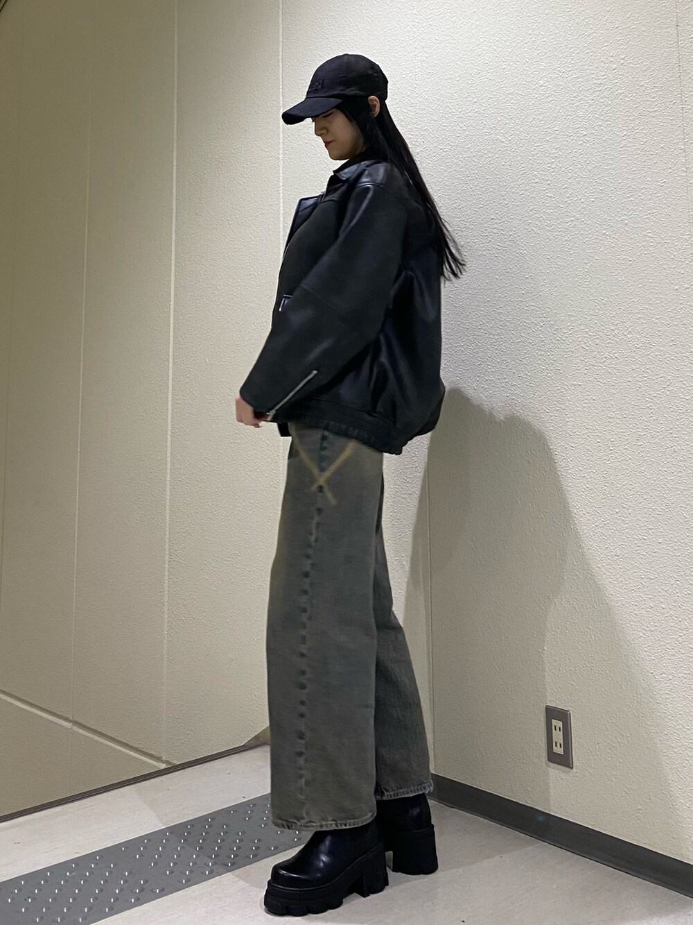 ブルー系のデニムパンツ、ブラック系のブルゾン、ブラック系のニット/セーターを着用したレディースの冬コーディネートの5枚目の写真