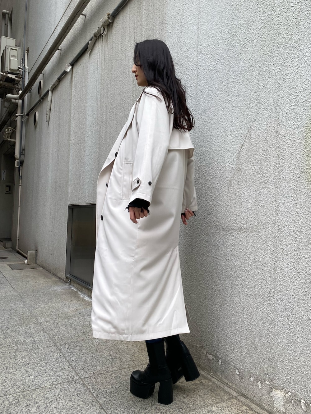 ブラック系のニット/セーター、ブルー系のデニムパンツ、ブラック系のブーツを着用したレディースの冬コーディネートの2枚目の写真