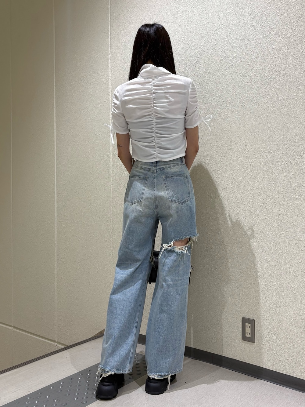 ブルー系のデニムパンツ、ホワイト系のシャツ/ブラウス、ブラック系のサンダルを着用したレディースの春コーディネートの3枚目の写真