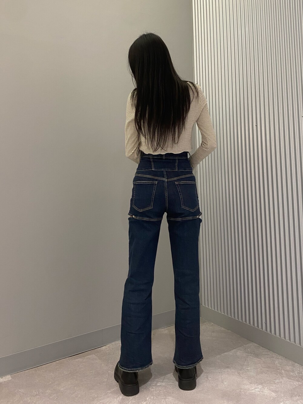 ブラック系のブーツ、ブルー系のデニムパンツ、その他のTシャツ/カットソーを着用したレディースの春コーディネートの5枚目の写真