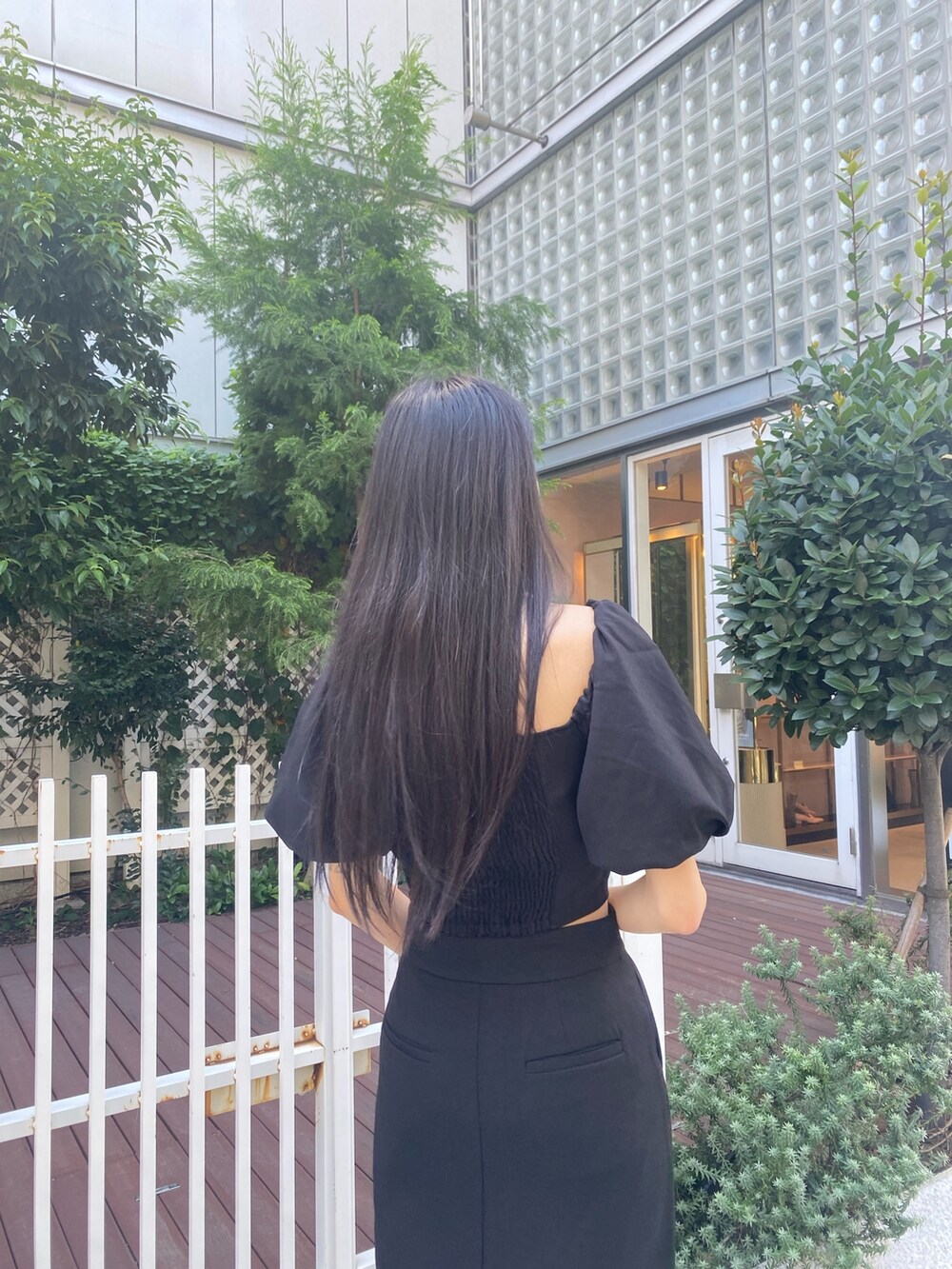 ブラック系のスカート、ブラック系のTシャツ/カットソー、シルバー系のネックレスを着用したレディースの夏コーディネートの7枚目の写真