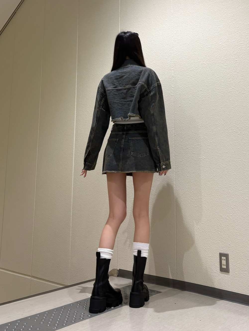 ブルー系のスカート、ブルー系のデニムジャケット、ホワイト系のキャミソールを着用したレディースの夏コーディネートの4枚目の写真