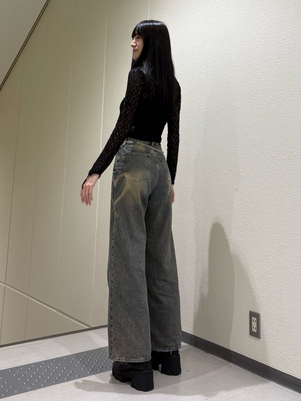 ブルー系のデニムパンツ、ブラック系のTシャツ/カットソー、ブラック系のブーツを着用したレディースの春コーディネートの3枚目の写真