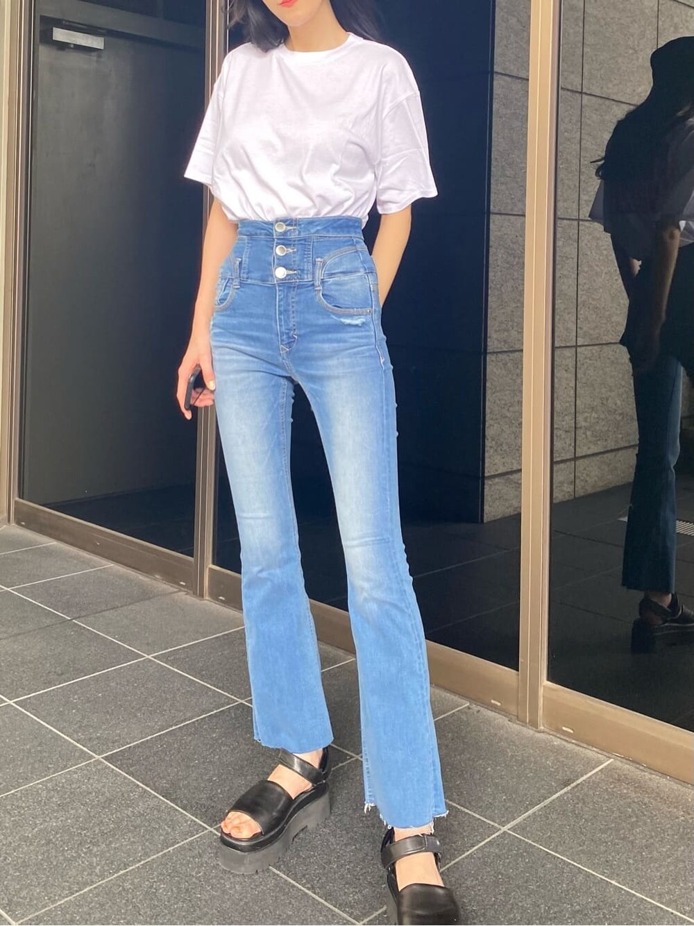 ブラック系のサンダル、ブルー系のデニムパンツ、ホワイト系のTシャツ/カットソーを着用したレディースの夏コーディネートの2枚目の写真