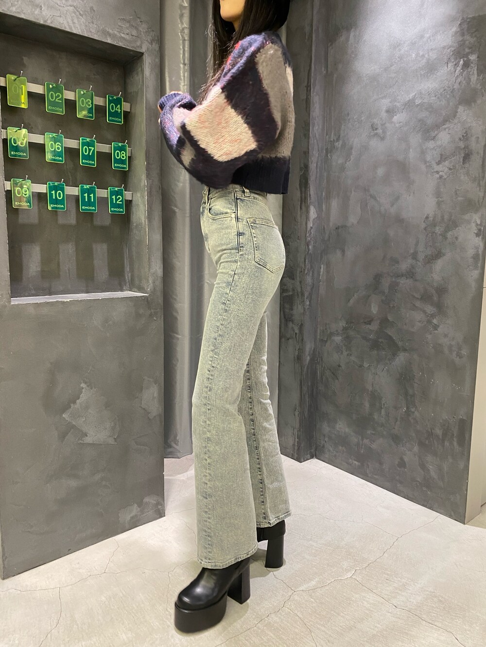 ブルー系のデニムパンツ、ブルー系のニット/セーター、ブラック系のブーツを着用したレディースの秋コーディネートの9枚目の写真