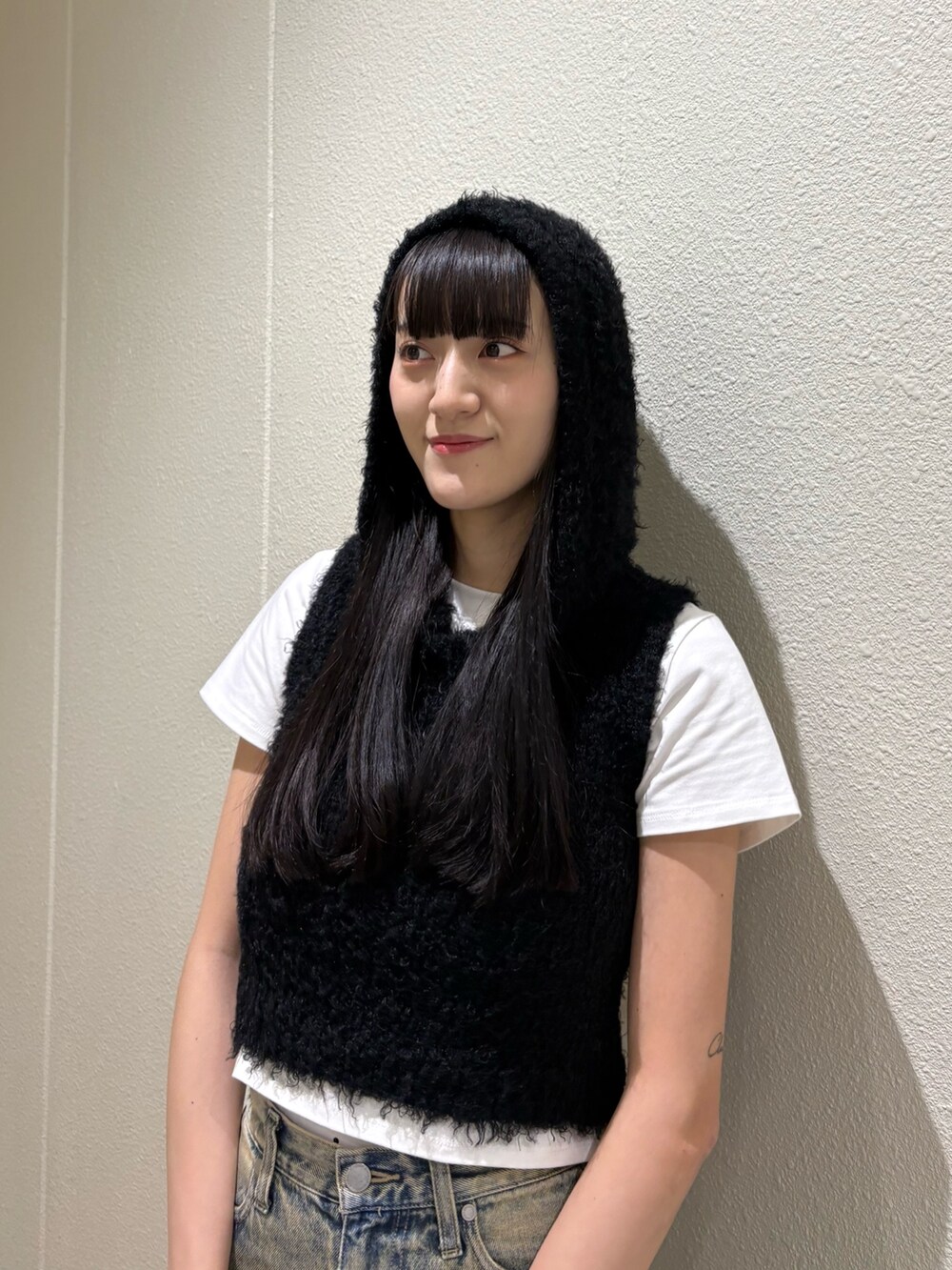 ブルー系のデニムパンツ、ブラック系のハンドバッグ、ホワイト系のTシャツ/カットソーを着用したレディースの春コーディネートの8枚目の写真