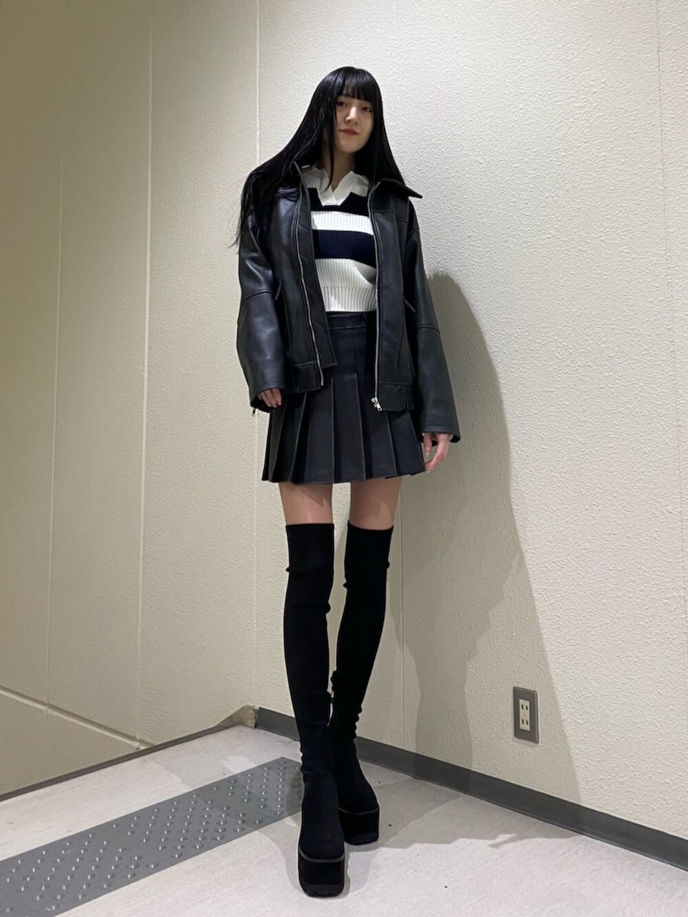 ブラック系のスカート、その他のニット/セーター、ブラック系のブーツを着用したレディースの冬コーディネートの2枚目の写真