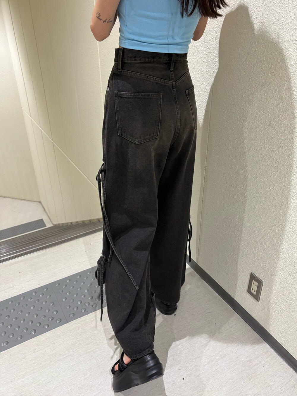 ブルー系のTシャツ/カットソー、ブラック系のデニムパンツ、ブラック系のサンダルを着用したレディースの春コーディネートの9枚目の写真