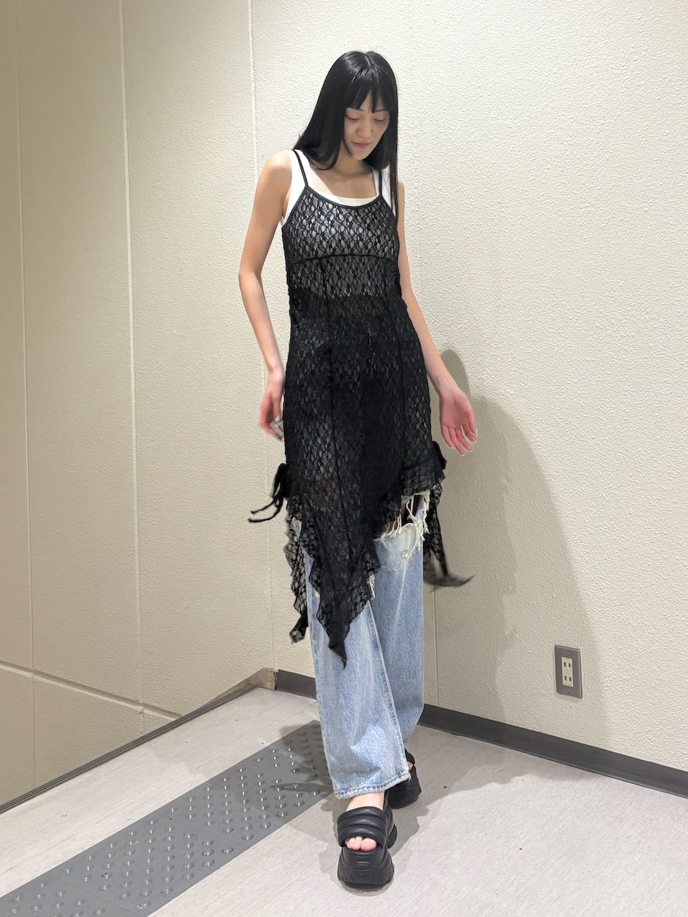 ホワイト系のニット/セーター、ブラック系のワンピース、ブルー系のデニムパンツを着用したレディースの夏コーディネートの2枚目の写真