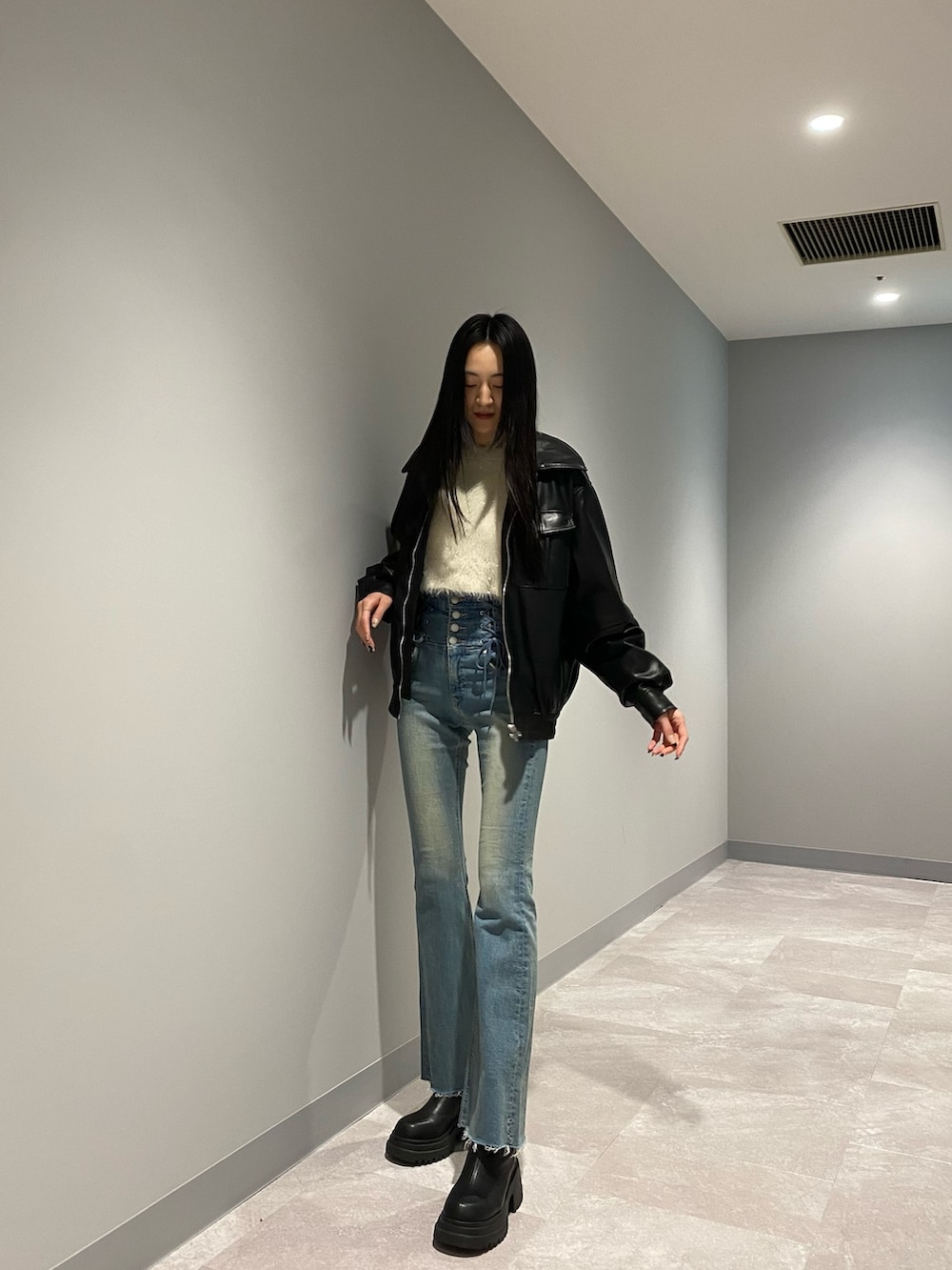 ブラック系のブルゾン、ブルー系のデニムパンツ、ホワイト系のニット/セーターを着用したレディースの冬コーディネートの2枚目の写真