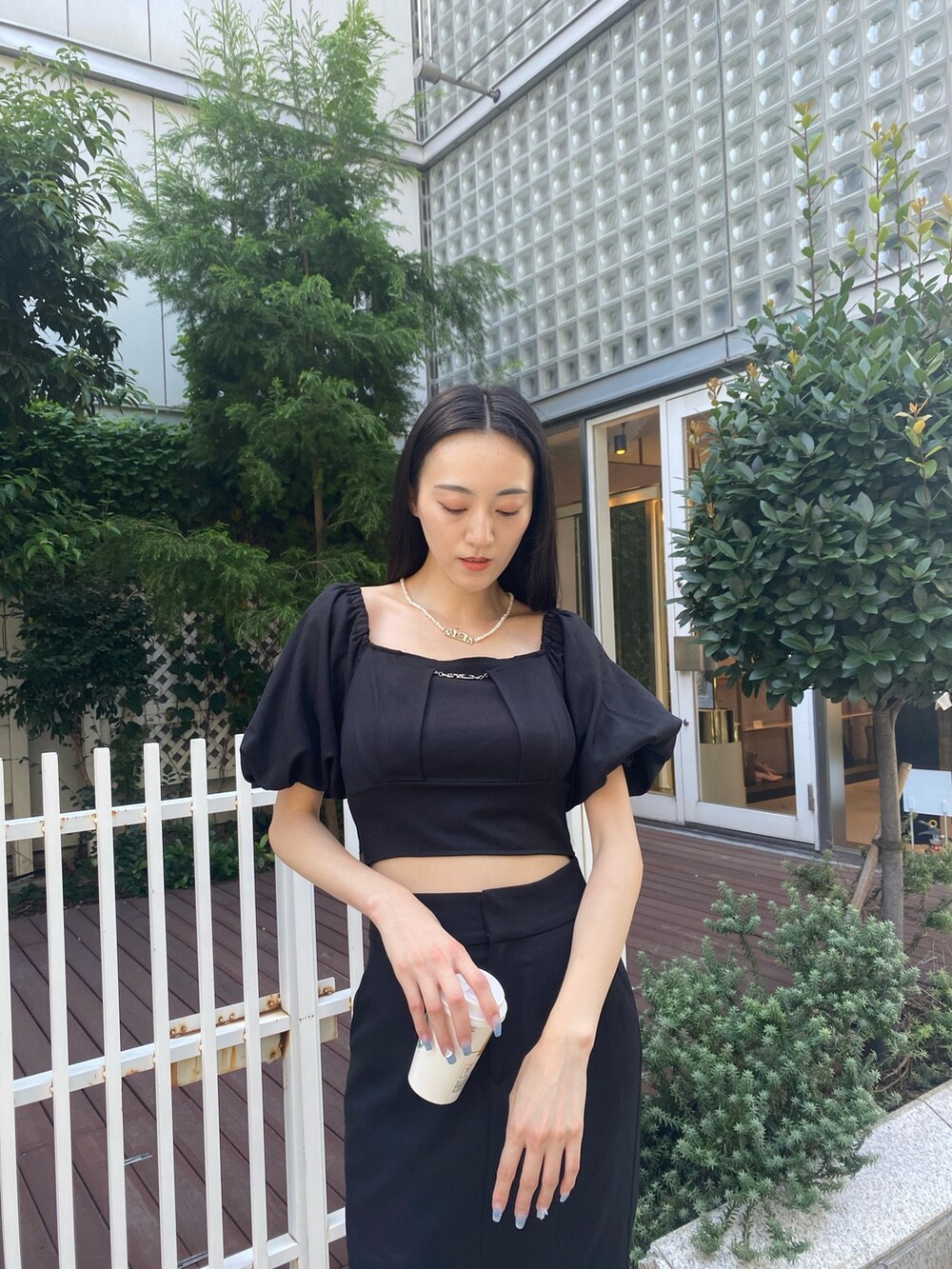 ブラック系のスカート、ブラック系のTシャツ/カットソー、シルバー系のネックレスを着用したレディースの夏コーディネートの5枚目の写真