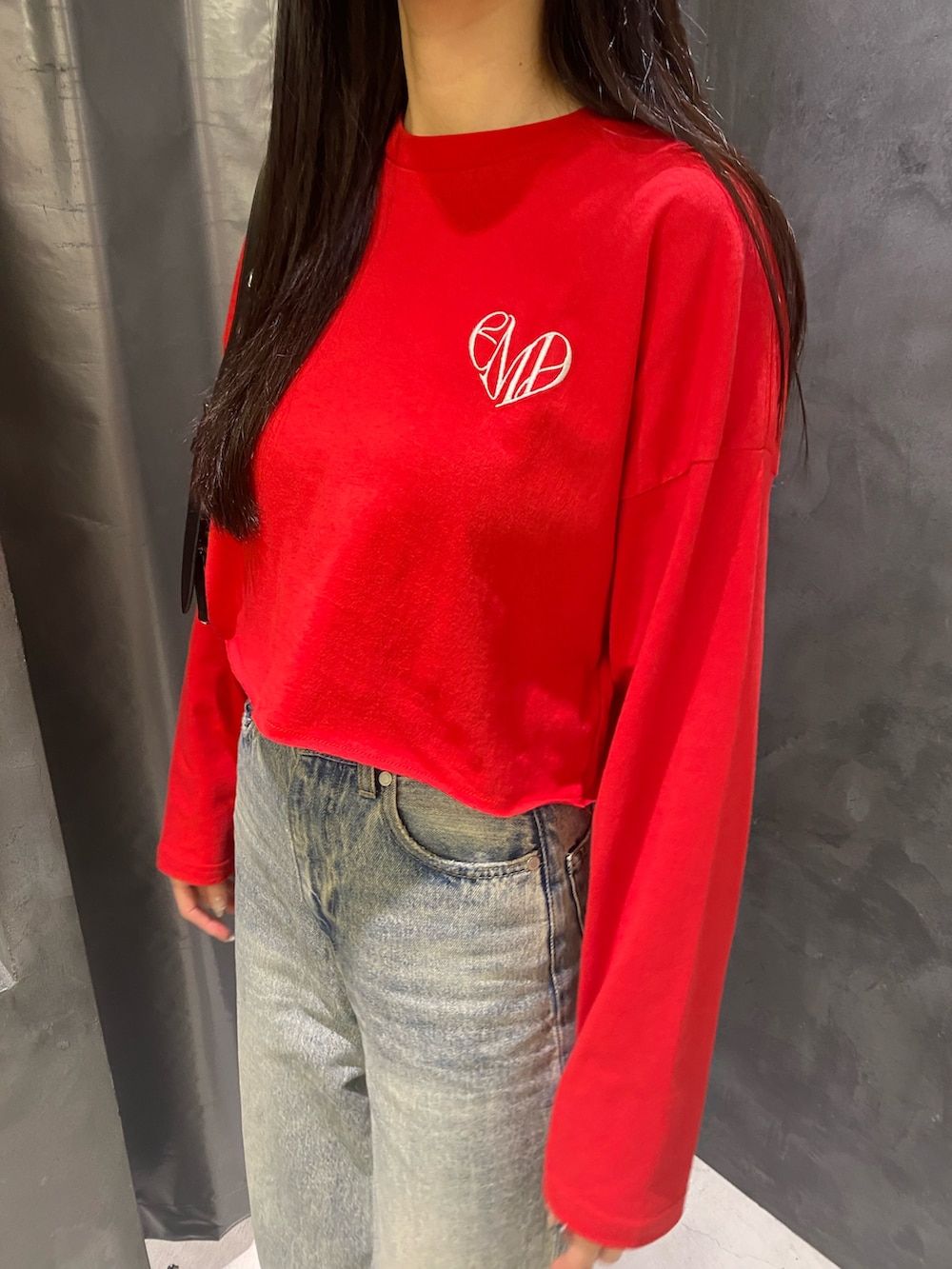 ブルー系のデニムパンツ、ブラック系のハンドバッグ、レッド系のTシャツ/カットソーを着用したレディースの秋コーディネートの7枚目の写真