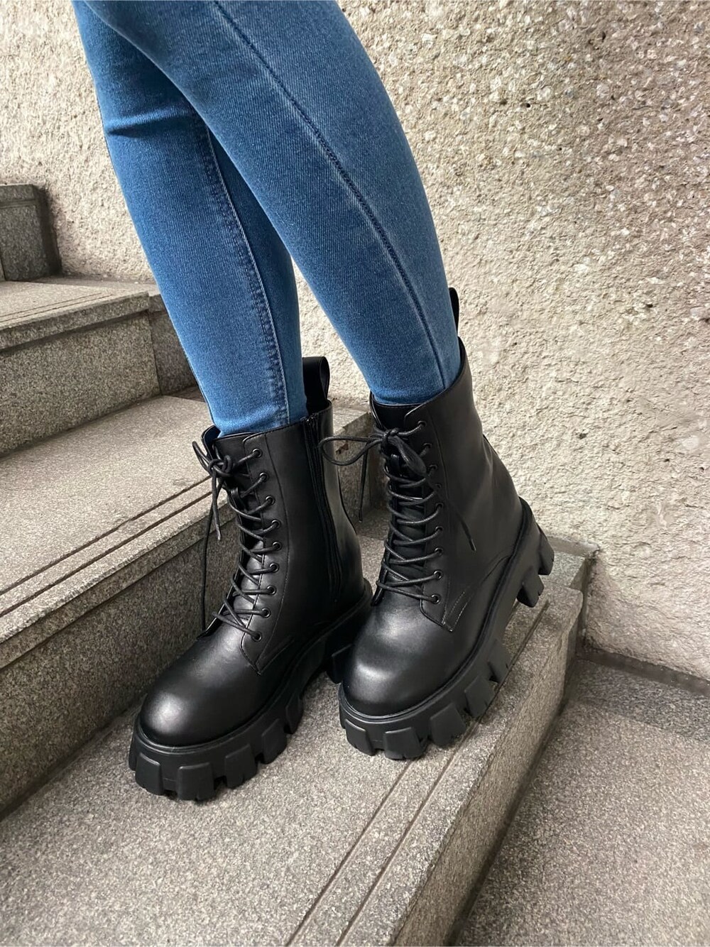 ブルー系のデニムパンツ、ブラック系のニット/セーター、ブラック系のブーツを着用したレディースの冬コーディネートの6枚目の写真