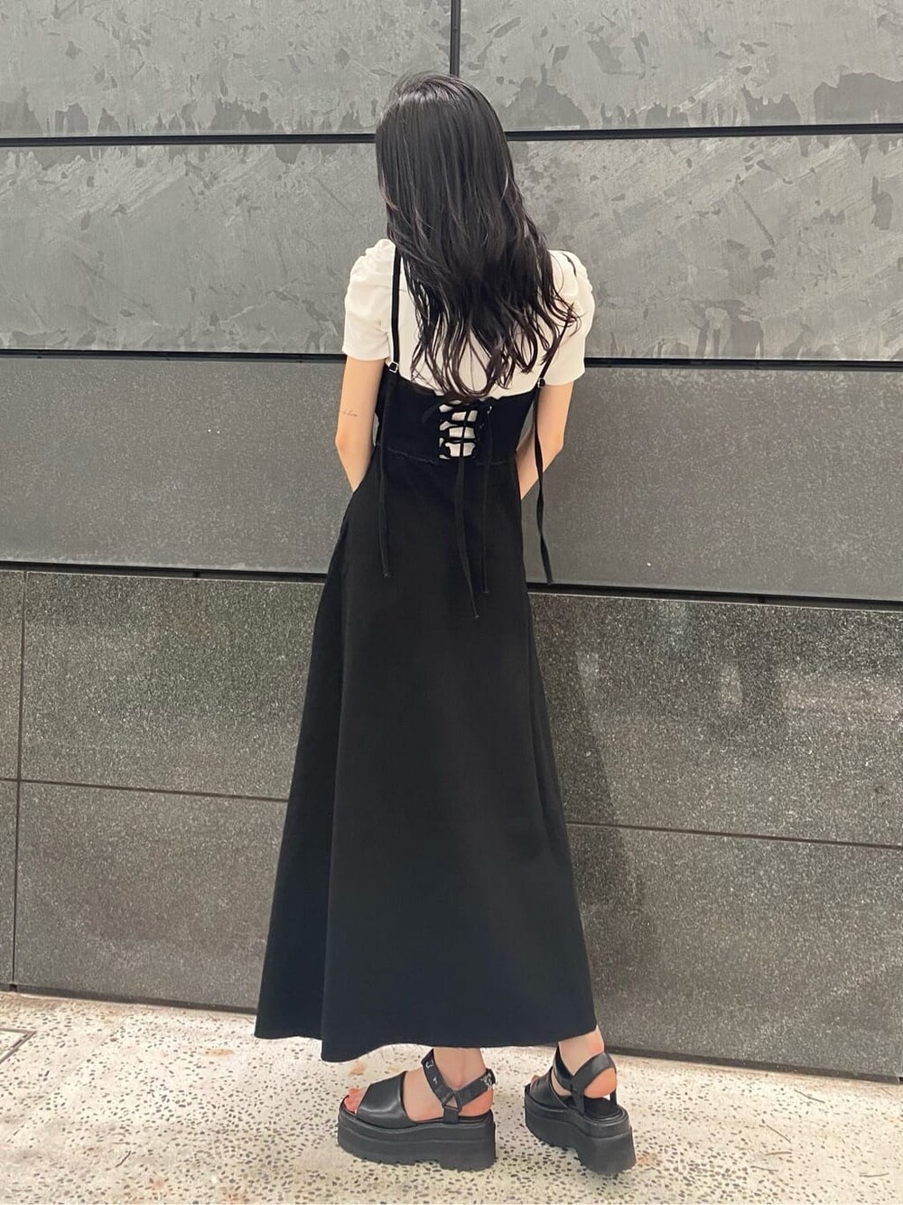 ブラック系のサンダル、ブラック系のワンピース、その他のハンドバッグを着用したレディースの夏コーディネートの3枚目の写真