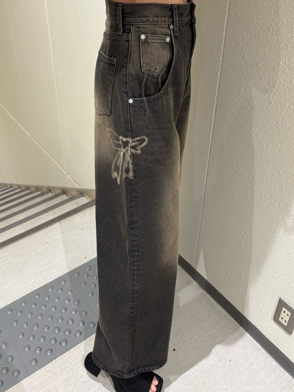 ブラック系のデニムパンツ、ブルー系のTシャツ/カットソー、ブラック系のサンダルを着用したレディースの夏コーディネートの6枚目の写真