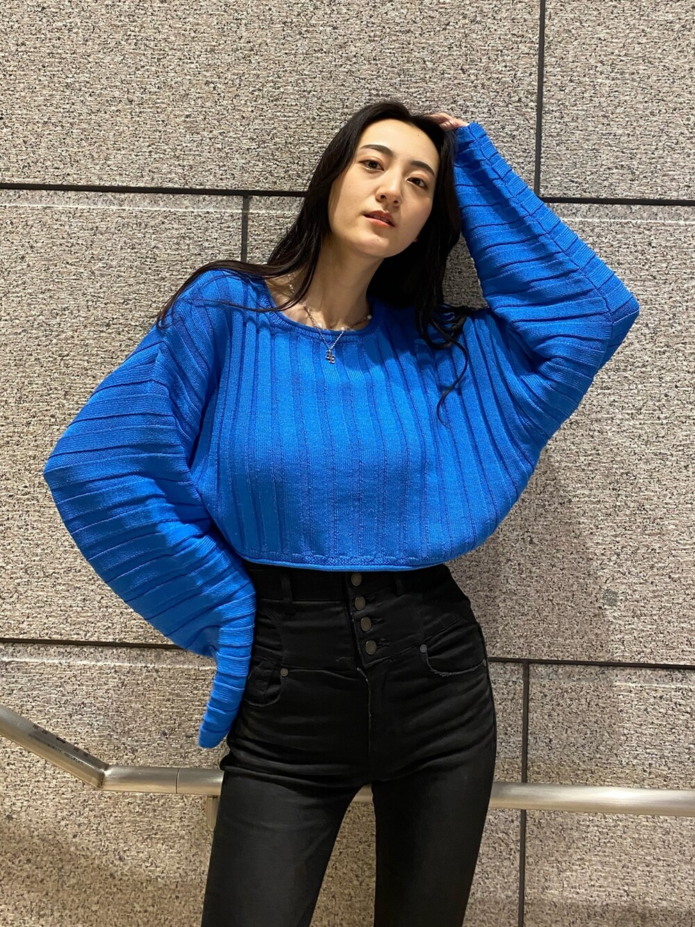 ホワイト系のブルゾン、ブルー系のニット/セーター、ブラック系のデニムパンツを着用したレディースの冬コーディネートの7枚目の写真