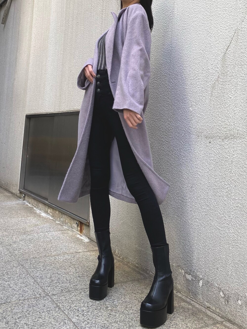 パープル系のチェスターコート、その他のニット/セーター、ブラック系のデニムパンツを着用したレディースの冬コーディネートの4枚目の写真