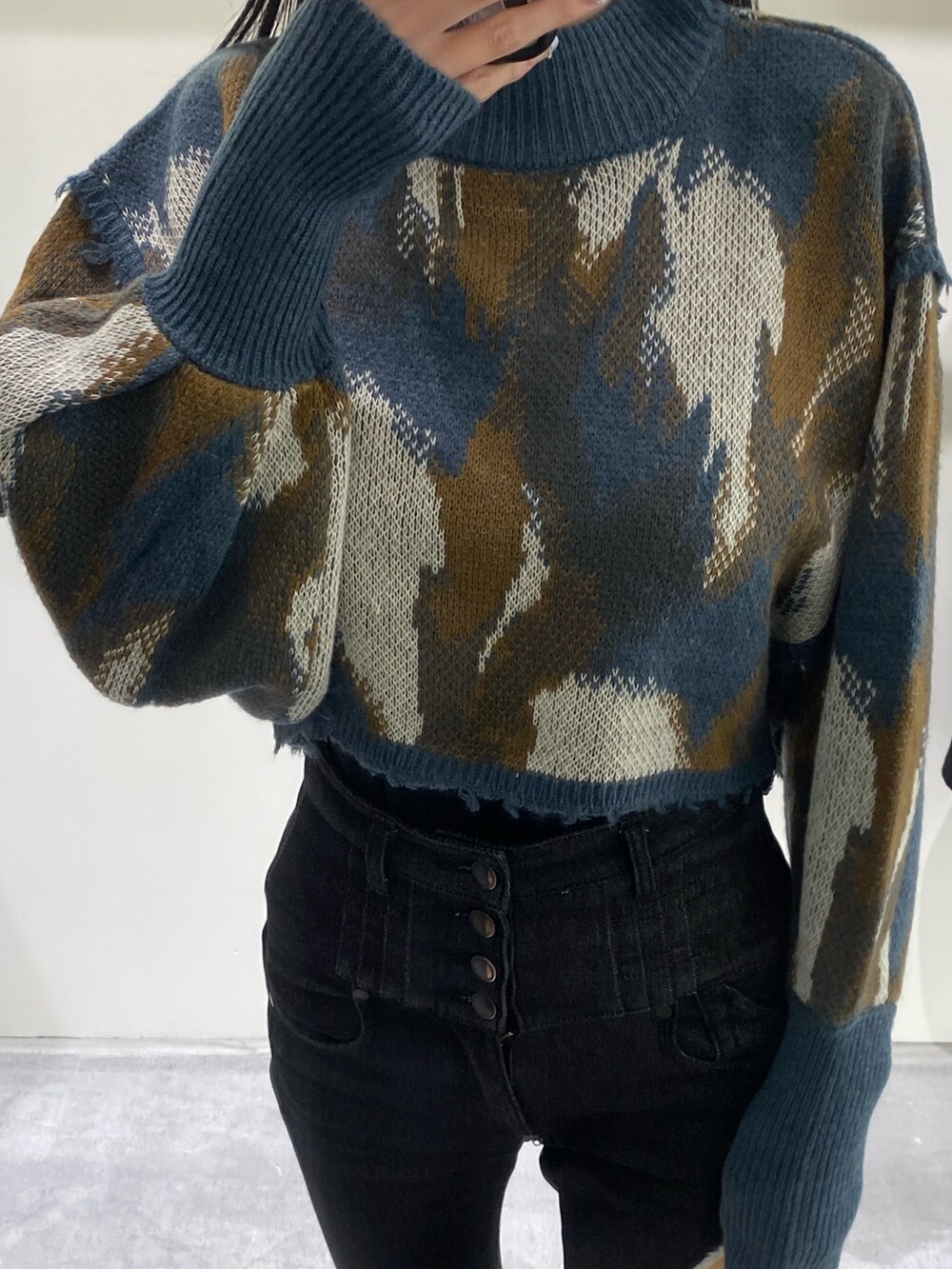 ベージュ系のハンドバッグ、ブラック系のデニムパンツ、ブルー系のニット/セーターを着用したレディースの秋コーディネートの2枚目の写真