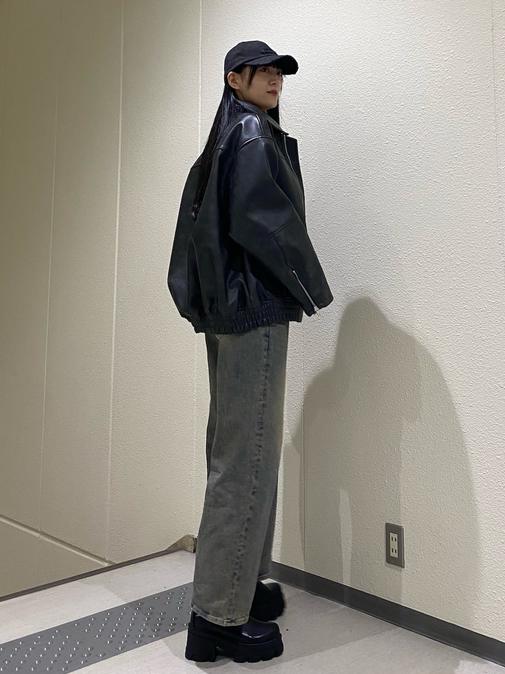 ブルー系のデニムパンツ、ブラック系のブルゾン、ブラック系のニット/セーターを着用したレディースの冬コーディネートの3枚目の写真