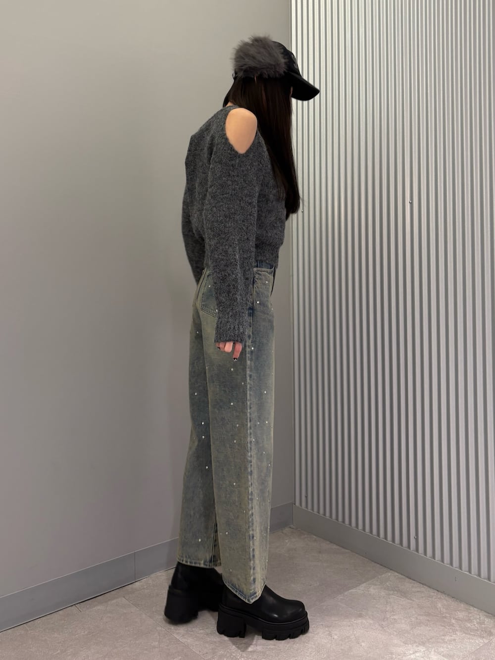 ブルー系のデニムパンツ、グレー系のニット/セーター、ブラック系のブーツを着用したレディースの冬コーディネートの5枚目の写真