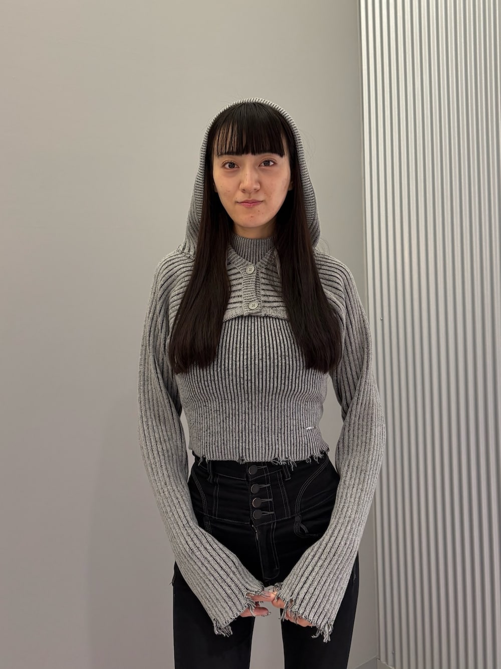 ブラック系のデニムパンツ、ブラック系のブーツ、グレー系のニット/セーターを着用したレディースの秋コーディネートの6枚目の写真