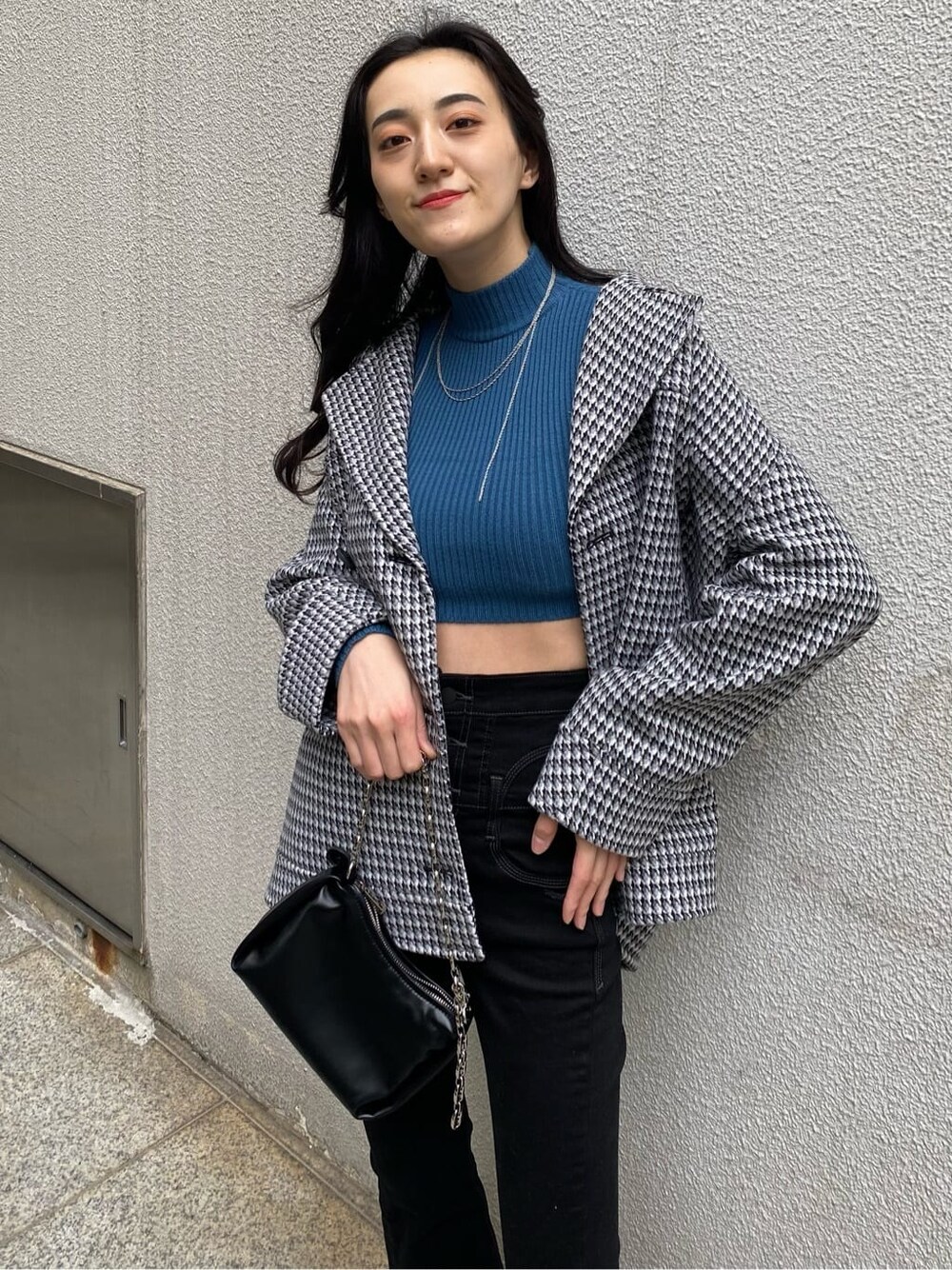 その他のテーラードジャケット、ブルー系のニット/セーター、ブラック系のハンドバッグを着用したレディースの秋コーディネートの6枚目の写真