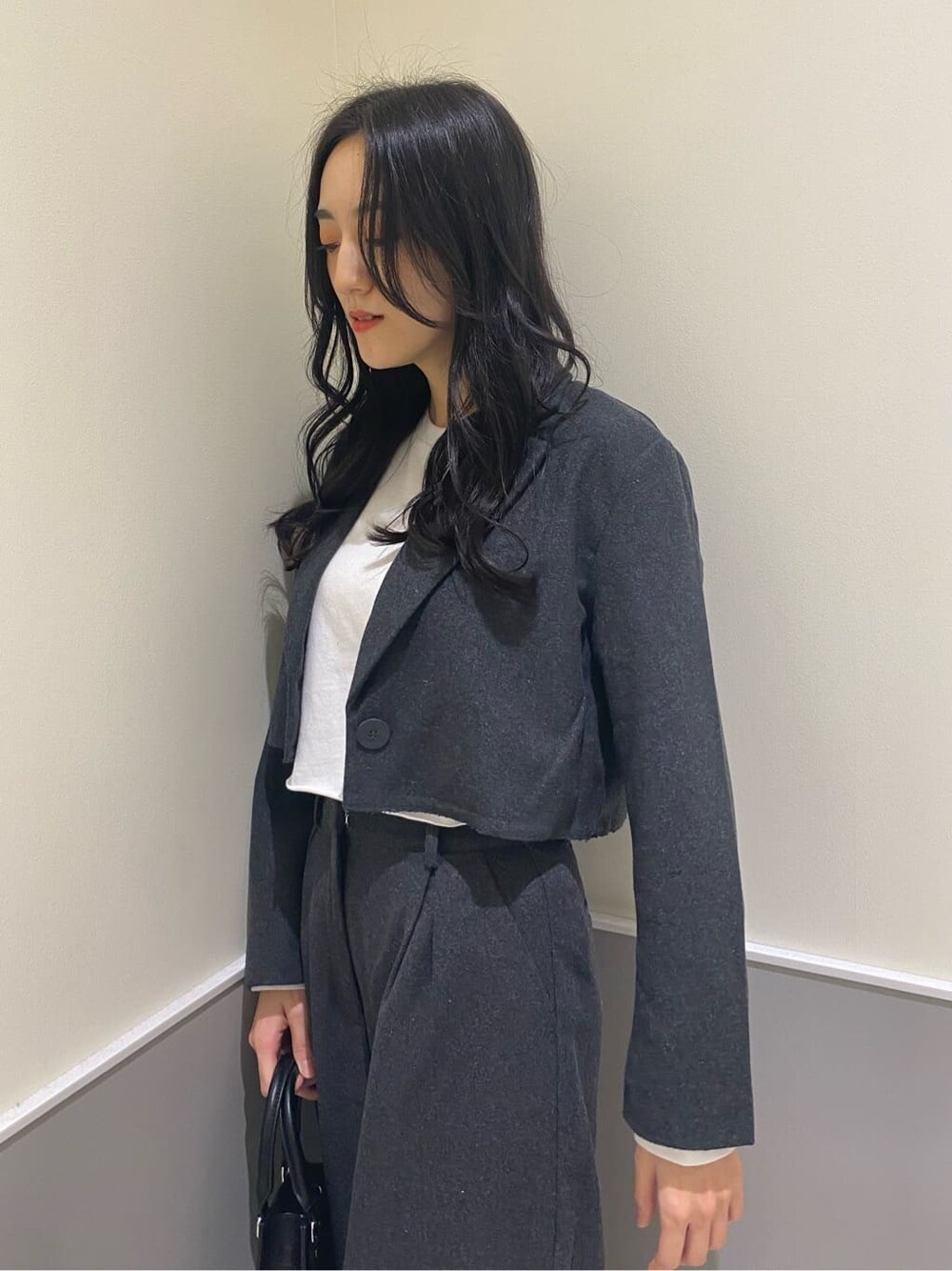 グレー系のテーラードジャケット、グレー系のその他パンツ、ブラック系のハンドバッグを着用したレディースの秋コーディネートの8枚目の写真