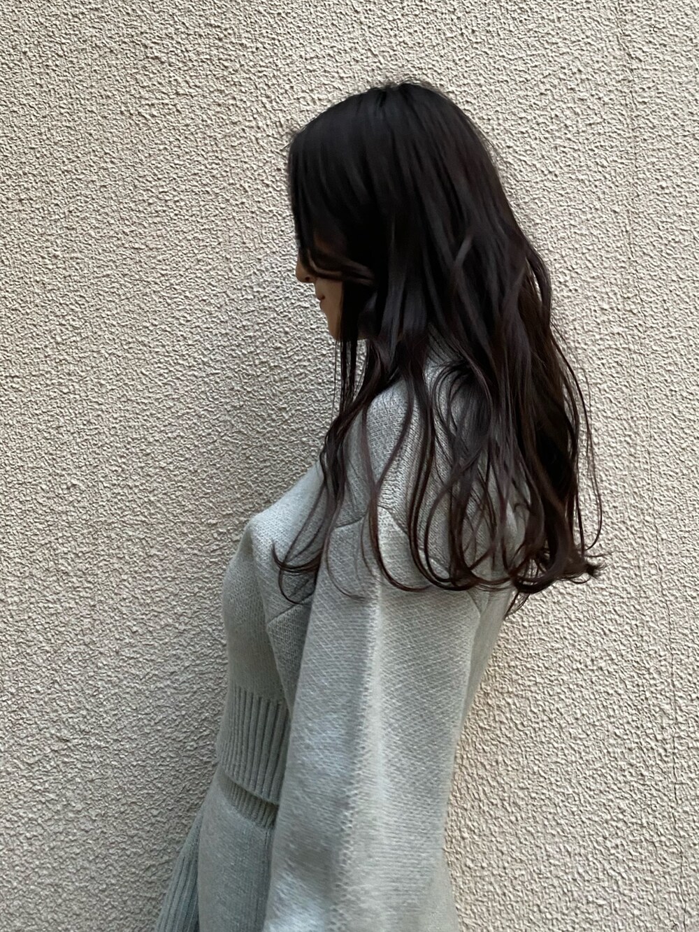 ブラック系のハンドバッグ、グレー系のスカート、グレー系のニット/セーターを着用したレディースの冬コーディネートの4枚目の写真