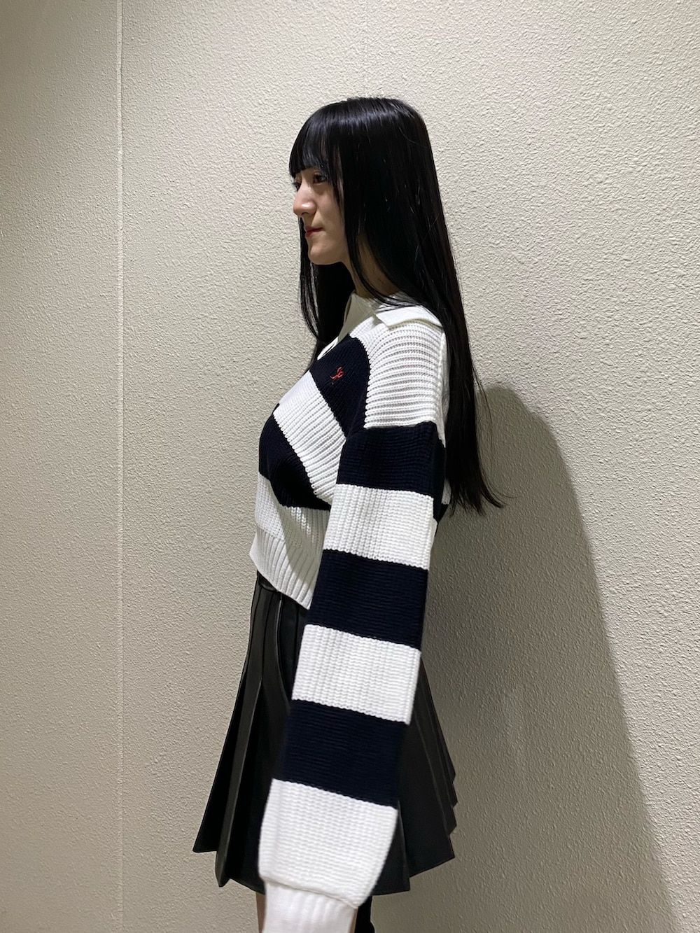 ブラック系のスカート、その他のニット/セーター、ブラック系のブーツを着用したレディースの冬コーディネートの7枚目の写真