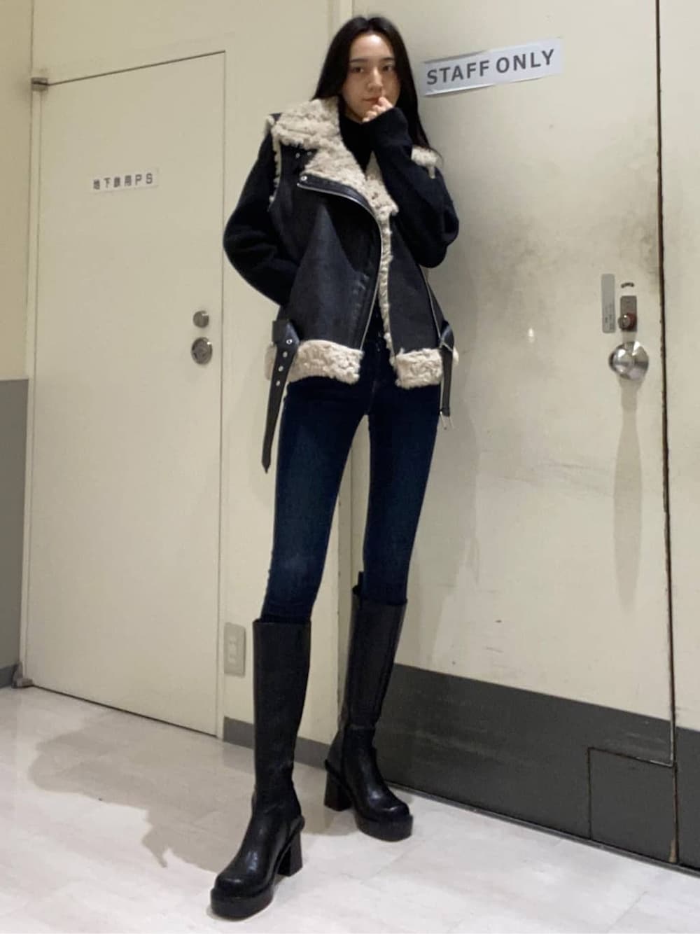 ブルー系のデニムパンツ、ブルー系のデニムパンツ、ブラック系のブーツを着用したレディースの秋コーディネートの2枚目の写真