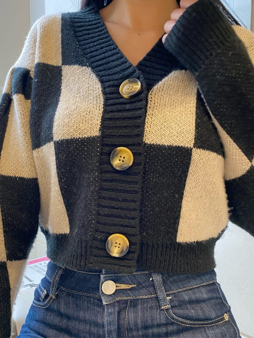 ブルー系のデニムパンツ、ブラック系のカーディガン/ボレロ、ベージュ系のハンドバッグを着用したレディースの冬コーディネートの6枚目の写真