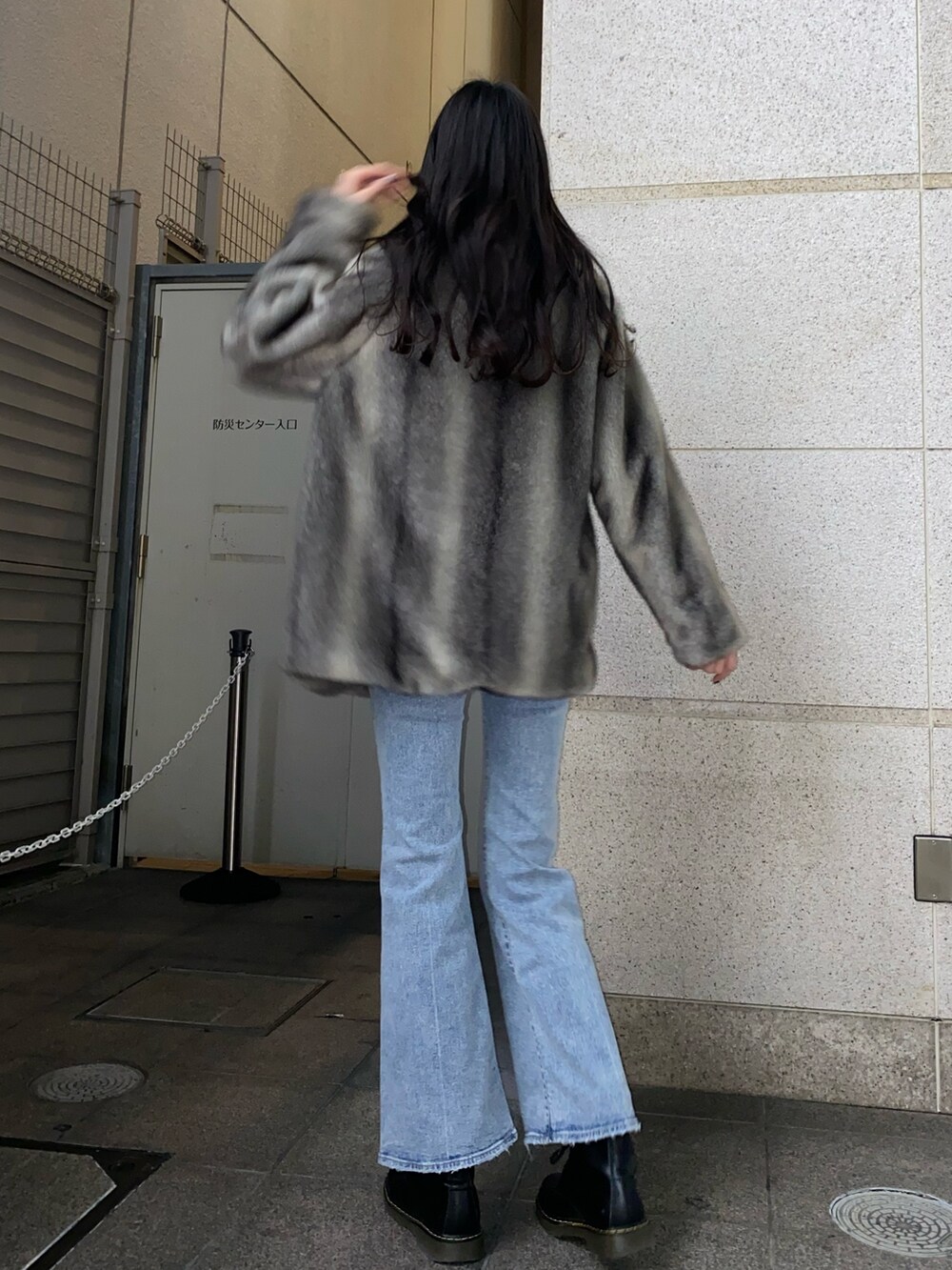 ブラック系のニット/セーター、グレー系のその他アウター、ブルー系のデニムパンツを着用したレディースの冬コーディネートの4枚目の写真