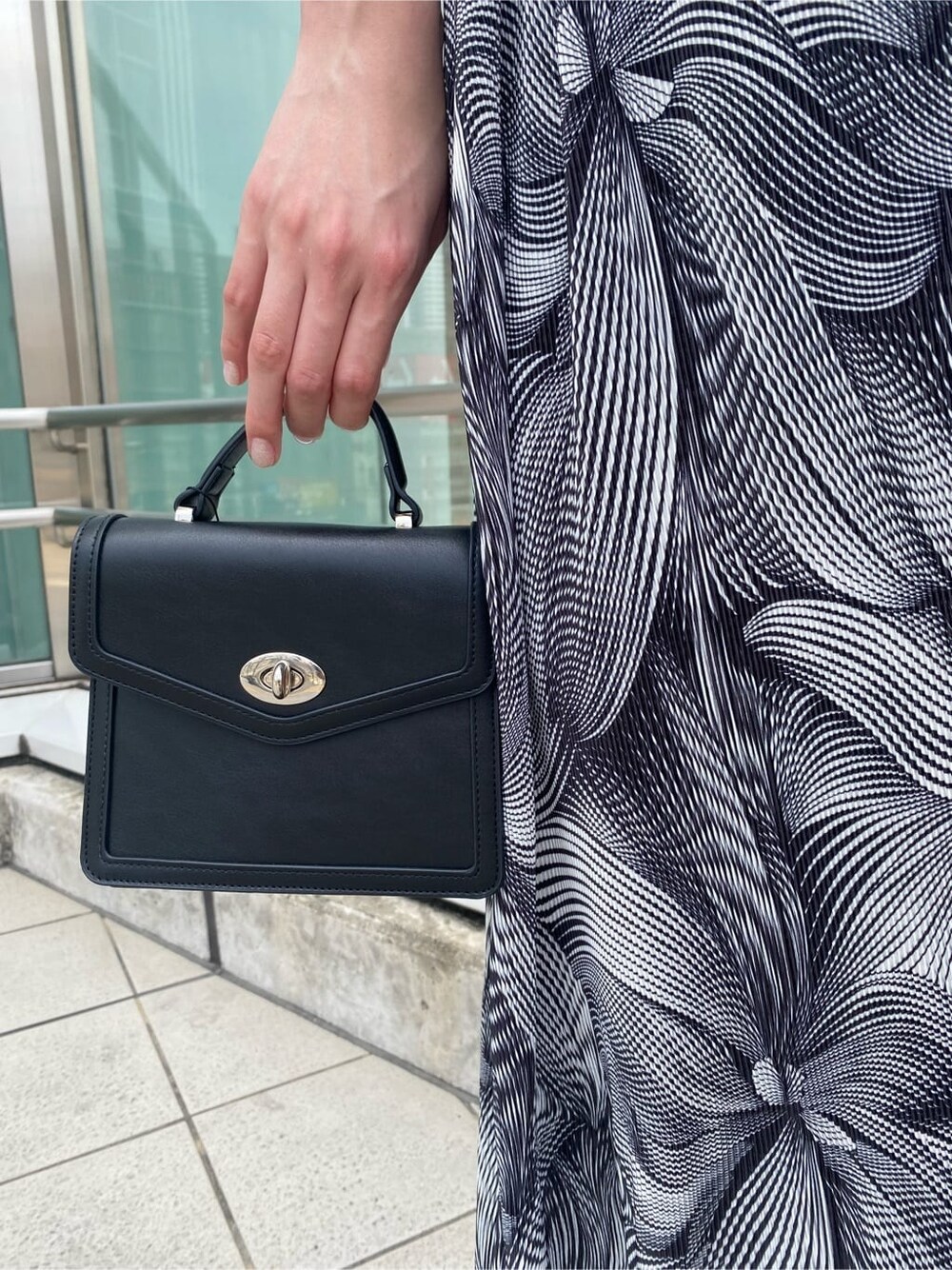 ブラック系のサンダル、ブラック系のハンドバッグ、その他のスカートを着用したレディースの夏コーディネートの8枚目の写真