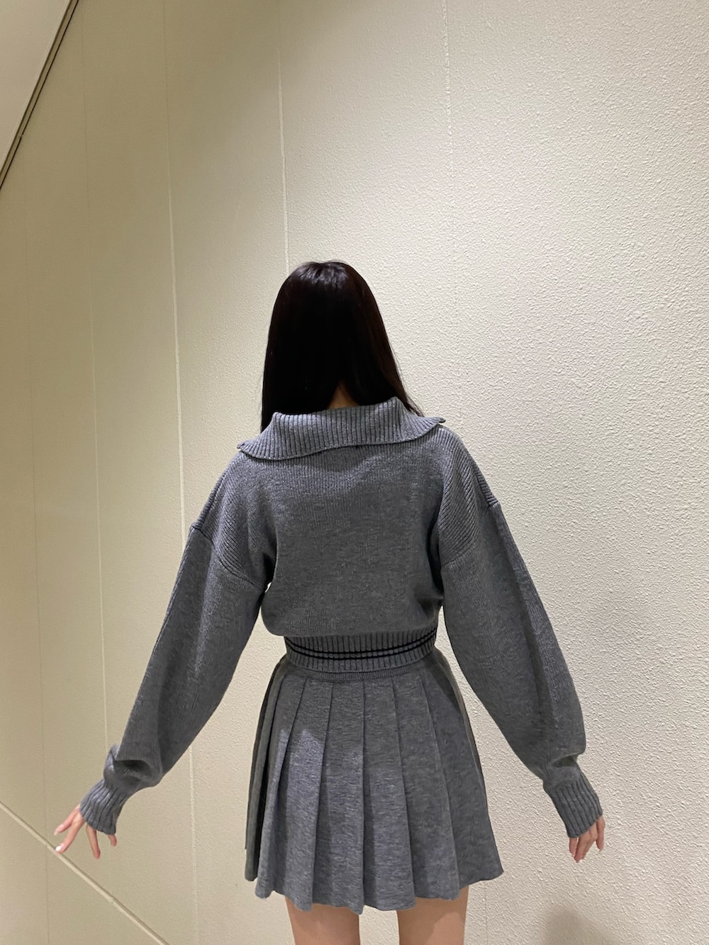 グレー系のニット/セーター、グレー系のスカート、その他のブーツを着用したレディースの秋コーディネートの7枚目の写真