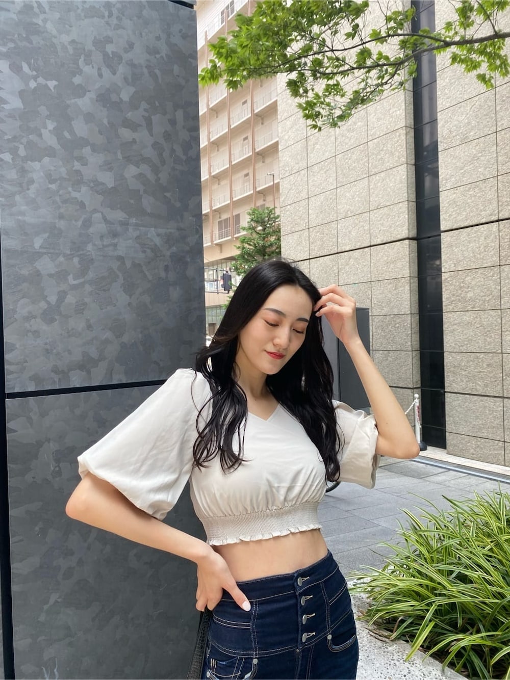 ブルー系のデニムパンツ、ホワイト系のTシャツ/カットソー、ブラック系のサンダルを着用したレディースの夏コーディネートの4枚目の写真