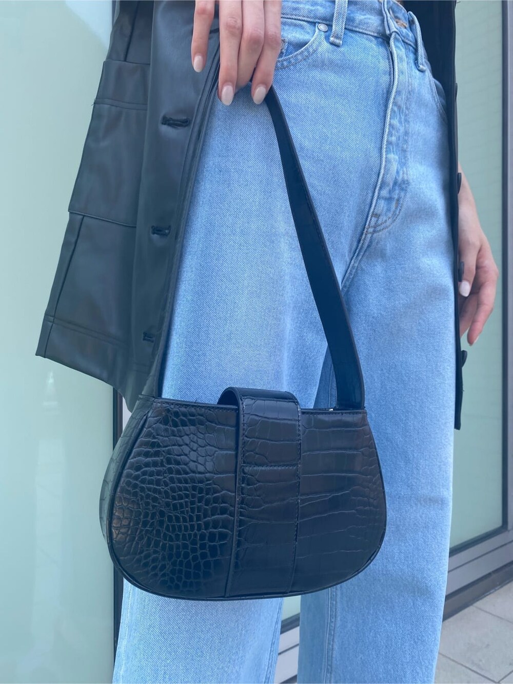 ブルー系のデニムパンツ、ブラック系のワンピース、ベージュ系のスリッポンを着用したレディースの夏コーディネートの9枚目の写真