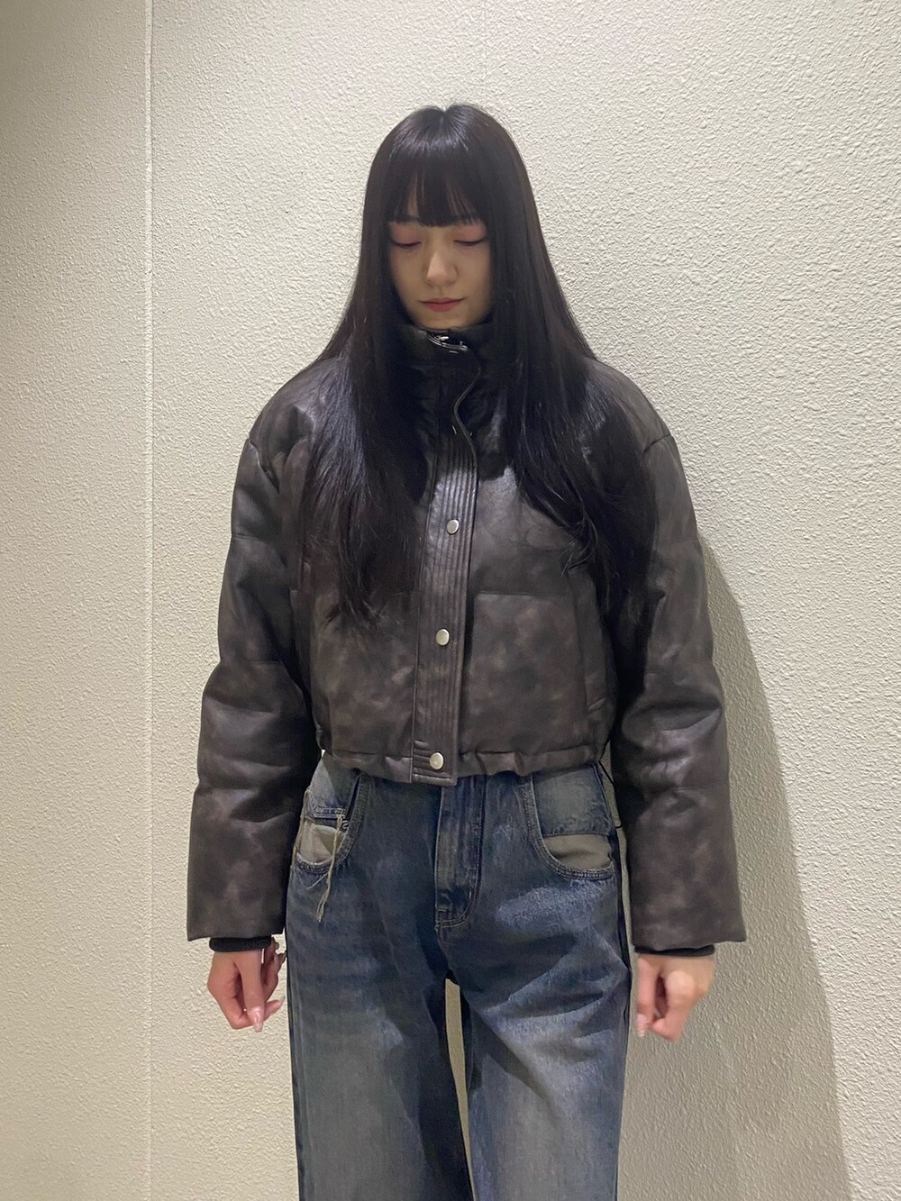 ブルー系のデニムパンツ、ブラウン系のダウンジャケット/コート、ブラック系のブーツを着用したレディースの冬コーディネートの7枚目の写真