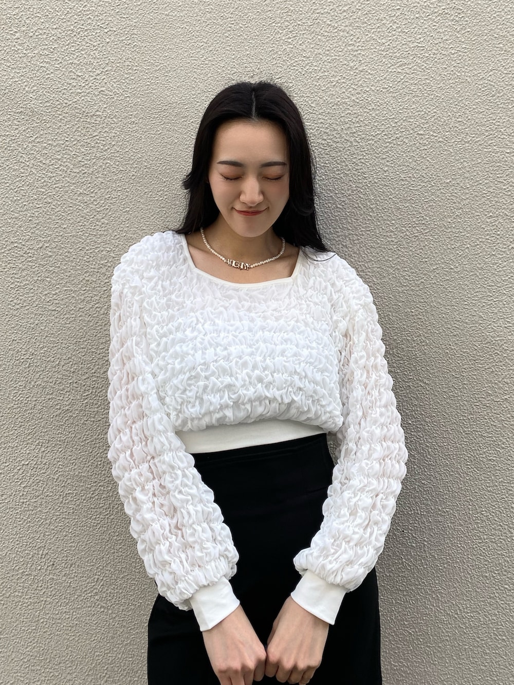 ホワイト系のTシャツ/カットソー、ブラック系のスカート、ブラック系のハンドバッグを着用したレディースの春コーディネートの3枚目の写真