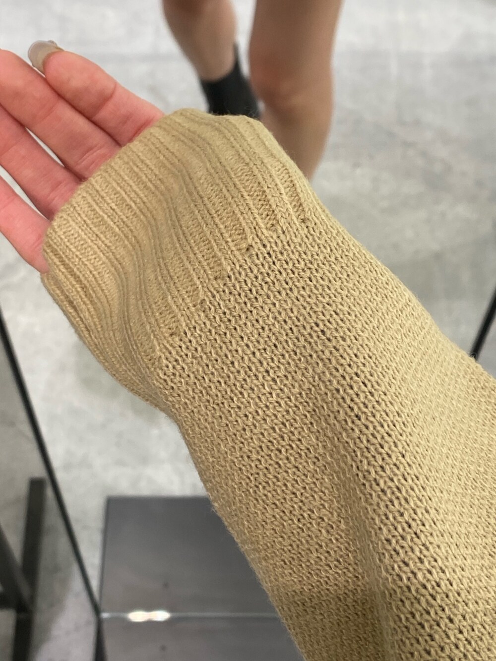 ベージュ系のニット/セーター、ベージュ系のスカート、ブラック系のブーツを着用したレディースの秋コーディネートの6枚目の写真