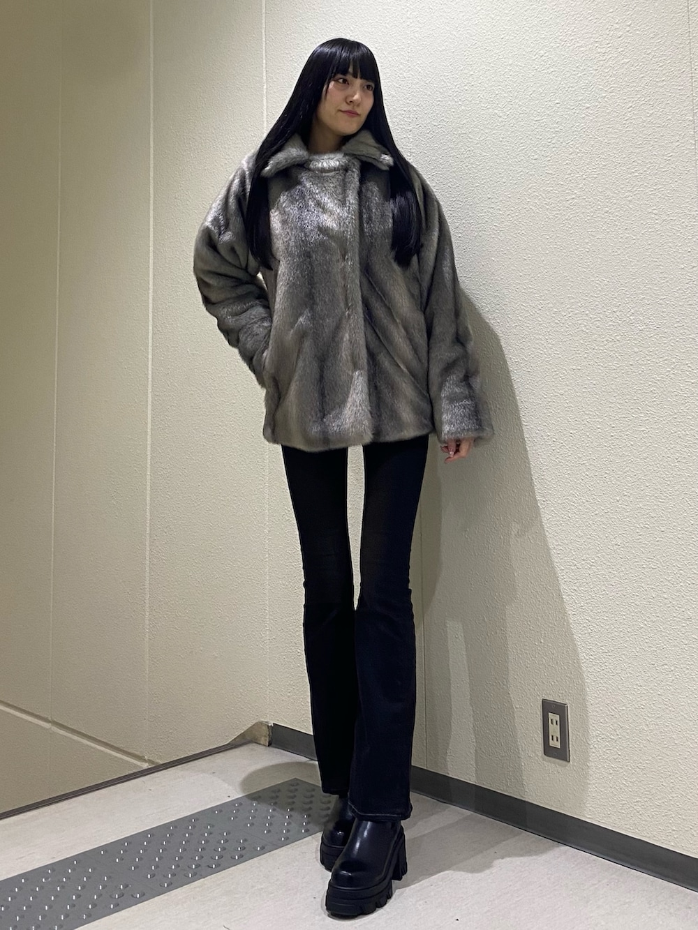 ブラック系のデニムパンツ、ブラック系のブーツ、ブラック系のニット/セーターを着用したレディースの冬コーディネートの2枚目の写真