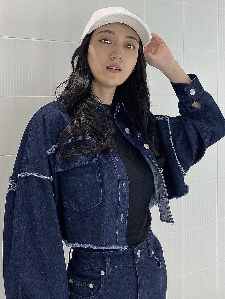 ブルー系のデニムジャケット、ブルー系のスカート、ホワイト系のハンドバッグを着用したレディースの夏コーディネートの5枚目の写真