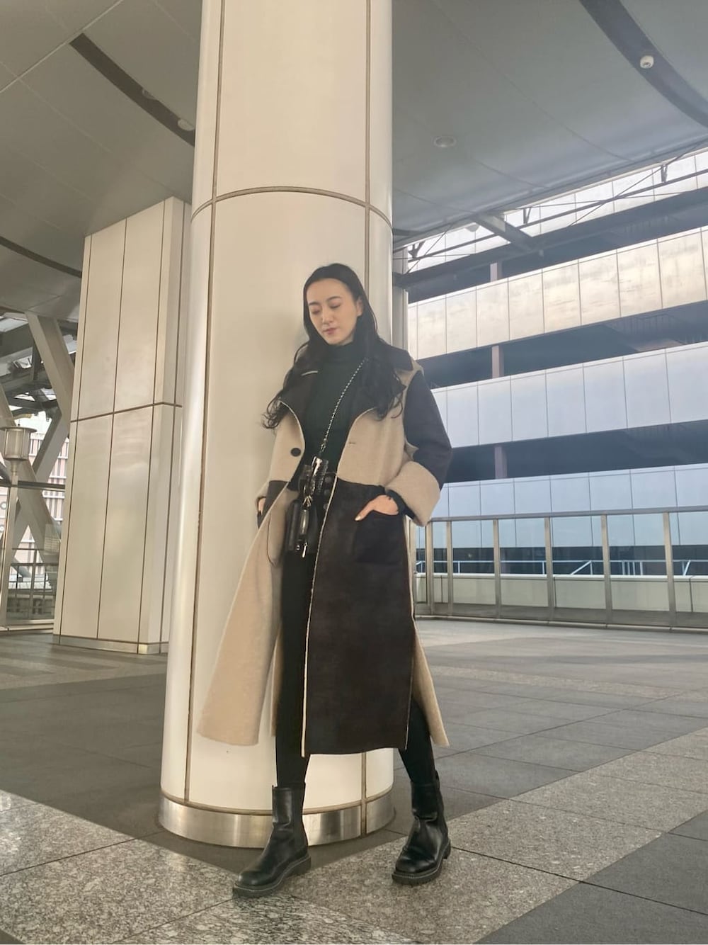 ブラック系のデニムパンツ、ブラック系のムートンコート、ブラック系のショルダーバッグを着用したレディースの冬コーディネートの2枚目の写真